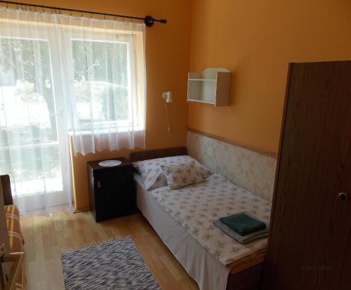 a small bedroom with a bed and a window at Bencze Vendégház Zalakaros in Zalakaros