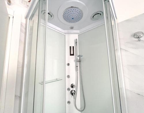 una doccia con una porta in vetro in un bagno di SEA PEARL Boutique Apartment - Bright and spacious, with modern Mediterranean décor, just 100 meters from the Lavinio seafront ad Anzio