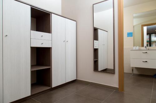 a bathroom with white cabinets and a mirror at Pierre & Vacances Barcelona Sants in Barcelona