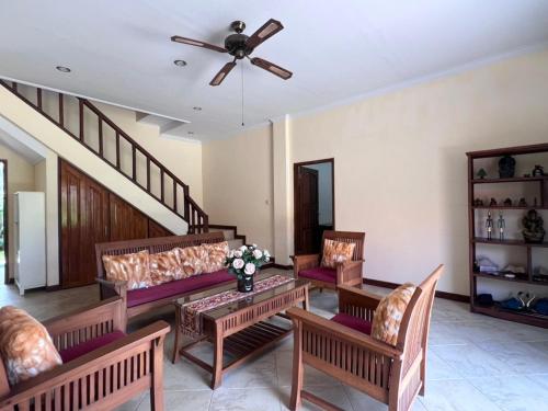 a living room with couches and a ceiling fan at Beachfront Villa Jepun Segara in Banjar