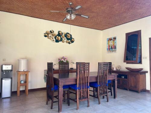 a dining room table with chairs and a ceiling fan at Beachfront Villa Jepun Segara in Banjar