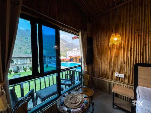 a room with a table and a window with a view at Euphoric Tiger Resort in Rishīkesh