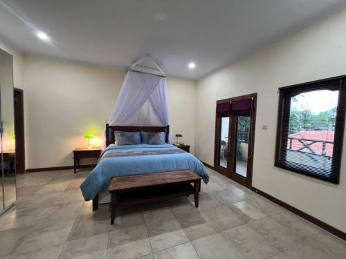 a bedroom with a bed with a canopy at Beachfront Villa Jepun Segara in Banjar