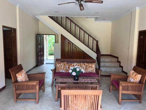 a living room with a couch and chairs and stairs at Beachfront Villa Jepun Segara in Banjar