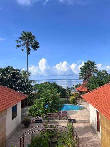 a resort with a swimming pool and a palm tree at Beachfront Villa Jepun Segara in Banjar