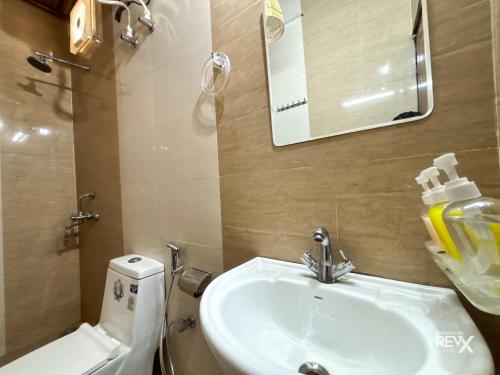 a bathroom with a sink and a toilet and a mirror at Euphoric Tiger Resort in Rishīkesh