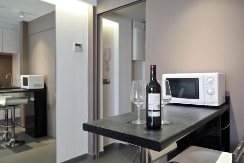 a bottle of wine and a wine glass on a table in a kitchen at Barcelona Fifteen central Aparthotel in Barcelona