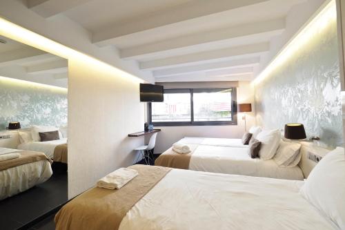a hotel room with two beds and a window at Barcelona Fifteen central Aparthotel in Barcelona
