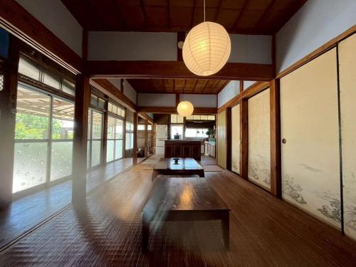 a living room with a table and a chandelier at -大人数で泊まれる一棟貸し-なかまあじーんやー海近くの素敵な島暮らし体験-手久津久- in Kikaiga Shima