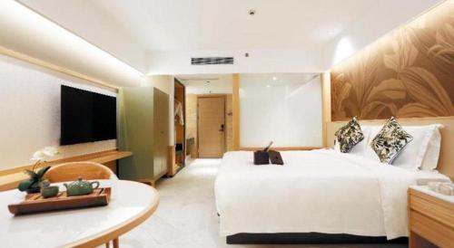a bedroom with a large white bed and a television at Kingtown Hotel Hongqiao Shanghai in Shanghai