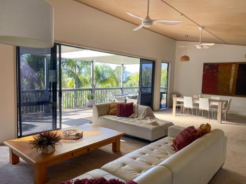 a living room with two couches and a table at Harrisons Retreat Premium Stay in Cable Bay