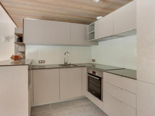 une cuisine avec des armoires blanches et un évier dans l'établissement Superbe appartement 3 pièces cabine à Méribel, proche pistes, avec parking et WIFI incl. - FR-1-411-985, à Les Allues