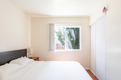 a bedroom with a white bed and a window at Modern & Cozy 2 Bedroom 2 Bathroom Sofabed Suite in Albany