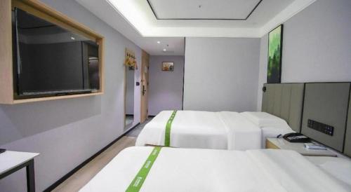 Ένα ή περισσότερα κρεβάτια σε δωμάτιο στο GreenTree Inn LiaoCheng LinQing HaiShan Building Express Hotel