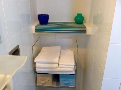 Un toallero con toallas y un jarrón azul. en Dimora Tipica Vista Mare, en Marettimo