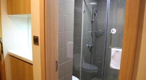 a shower with a glass door in a bathroom at IU Hotel Chengdu High-Tech Zone Longhu Times Street in Chengdu