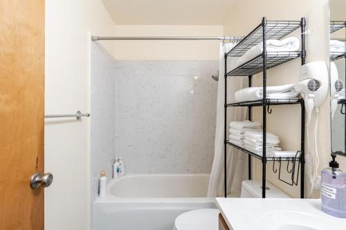 a bathroom with a tub and a toilet and a sink at Modern & Cozy 2 Bedroom 2 Bathroom Sofabed Suite in Albany