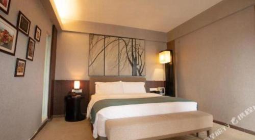 a bedroom with a large bed and a window at Chambery Hotel in Zhuhai