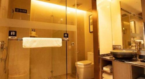 a bathroom with a shower and a toilet and a sink at Chambery Hotel in Zhuhai