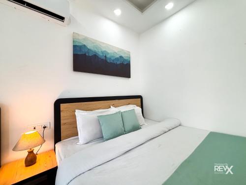a bedroom with a bed and a lamp on a table at Euphoric Tiger Resort in Rishīkesh