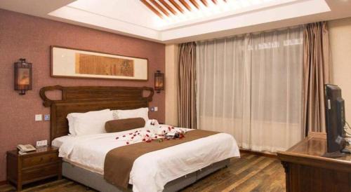 a bedroom with a large bed with roses on it at James Joyce Coffetel Xian Dayanta Metro Station Branch in Xi'an