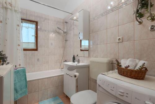 łazienka z toaletą, umywalką i wanną w obiekcie Komplett umzäuntes Ferienhaus mit Klima, WLAN w mieście Rakalj