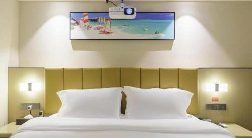 a bedroom with a large bed with white pillows at Jingtu hotel zhanjiang dingsheng plaza store in Zhanjiang