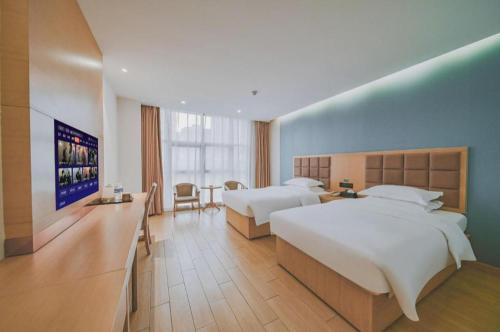 Una habitación de hotel con dos camas y un comedor. en GreenTree Inn Luoyang Train Station Zhuangyuanhong Road Hotel, en Luoyang