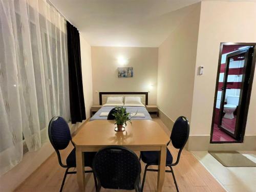 a room with a table and chairs and a bed at Стаи, студиа и апартаменти in Svishtov