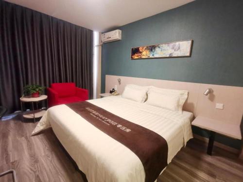 a hotel room with a large bed and a red chair at Zhangye Pinmu Hotel(Yuncheng Zhongyin Avenue Store) in Yuncheng
