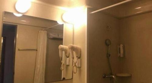 a bathroom with a mirror and a shower with towels at Zhangye Pinmu Hotel(Yuncheng Zhongyin Avenue Store) in Yuncheng