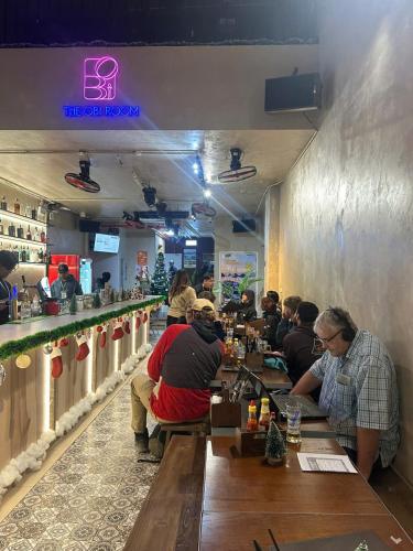 a group of people sitting at a bar in a restaurant at Quiri Hostel in Hanoi
