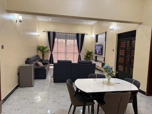 a living room with a table and a couch at Uptown retreat home Su casa Najjera 1 in Buwate