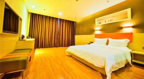 a bedroom with a large white bed and a window at 7 Days Premium·Shihezi Passenger Terminal in Shihezi