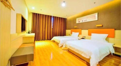 a hotel room with two beds and a television at 7 Days Premium·Shihezi Passenger Terminal in Shihezi
