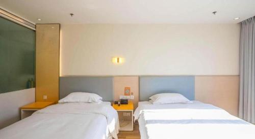 a room with two beds in a room at 7 Days Inn Harbin West Railway Station in Harbin