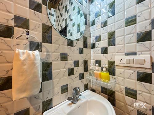 a bathroom with a sink and a mirror at Euphoric Tiger Resort in Rishīkesh