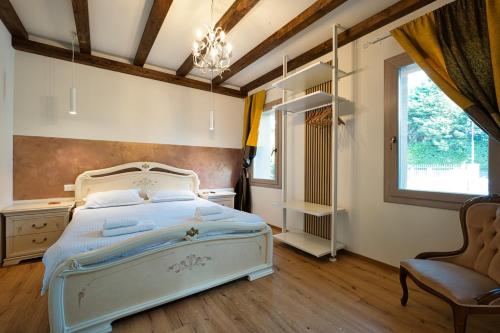 ein Schlafzimmer mit einem Bett, einem Stuhl und einem Fenster in der Unterkunft Free Parking Ap1 Romantic Garden Venice in Zelo