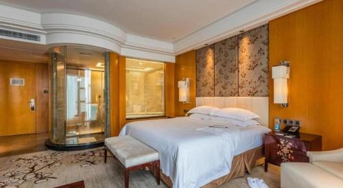 a bedroom with a large white bed and a window at Zhangjiagang Zhonglian GDH International Hotel in Zhangjiagang