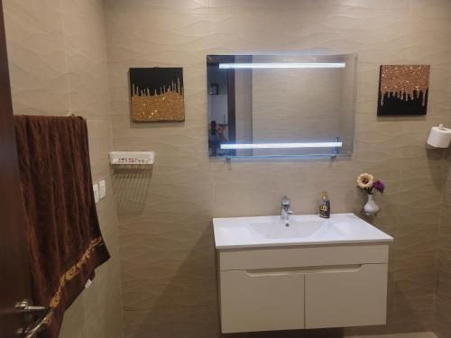 a bathroom with a sink and a mirror at Urban Escape Comfy Appartment in Dargai