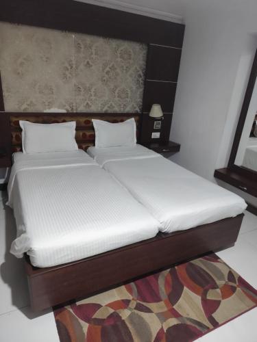 two beds sitting next to each other in a room at Airport City Hotel 