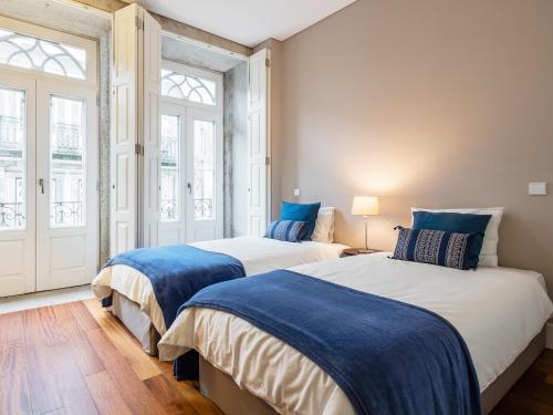 two beds in a room with two windows at Cardosas Boutique Apartment in Porto