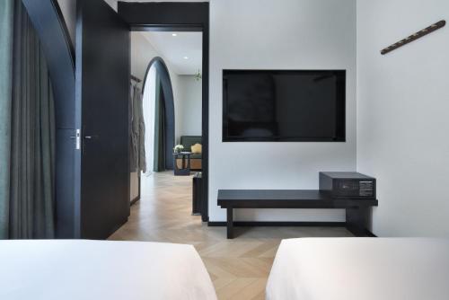 a room with two beds and a television on a wall at Norton Manor Yangshuo in Yangshuo