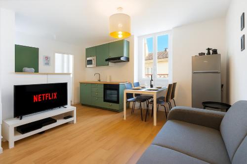 un salon avec un canapé et une télévision et une cuisine dans l'établissement Cosy Nest - parking - Netflix, à Valence