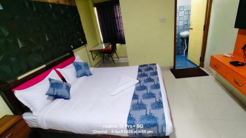 a bedroom with a bed with blue and white pillows at Archana Residency 