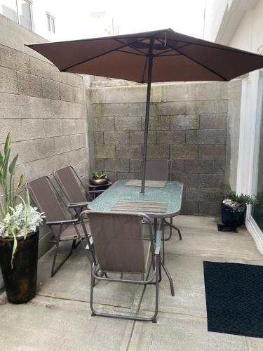 a table and chairs under an umbrella on a patio at Departamento en Boca del Rio Ver in Boca del Río
