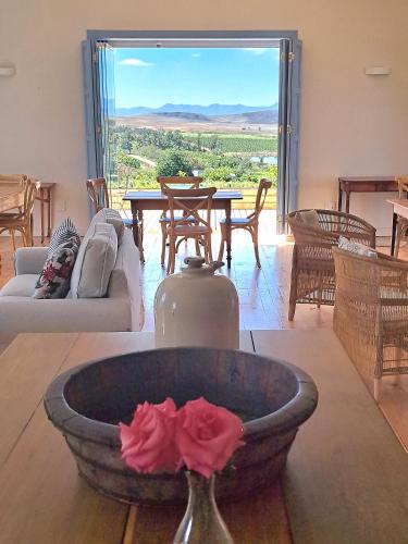 a living room with a table and a vase with a flower at Klaasvoogds Loft in Robertson