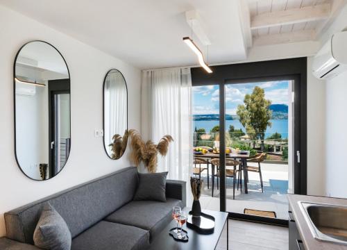 ein Wohnzimmer mit einem Sofa und eine Küche mit einem Tisch in der Unterkunft Pillow Apartments in Nikiana