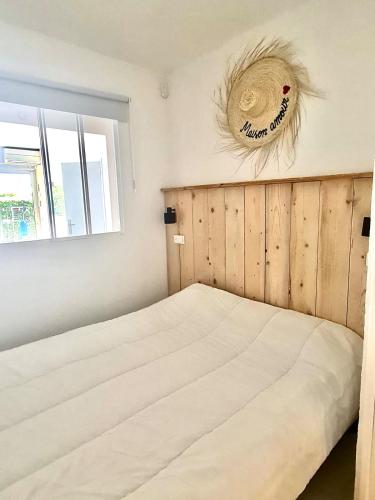 une chambre avec un lit avec une tête de lit en bois et une fenêtre dans l'établissement Rez de jardin 400 m de la mer, à Cavalaire-sur-Mer