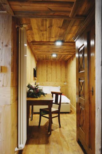 a room with a table and a bed in the background at Maison Carrel Elegant 12 in Breuil-Cervinia